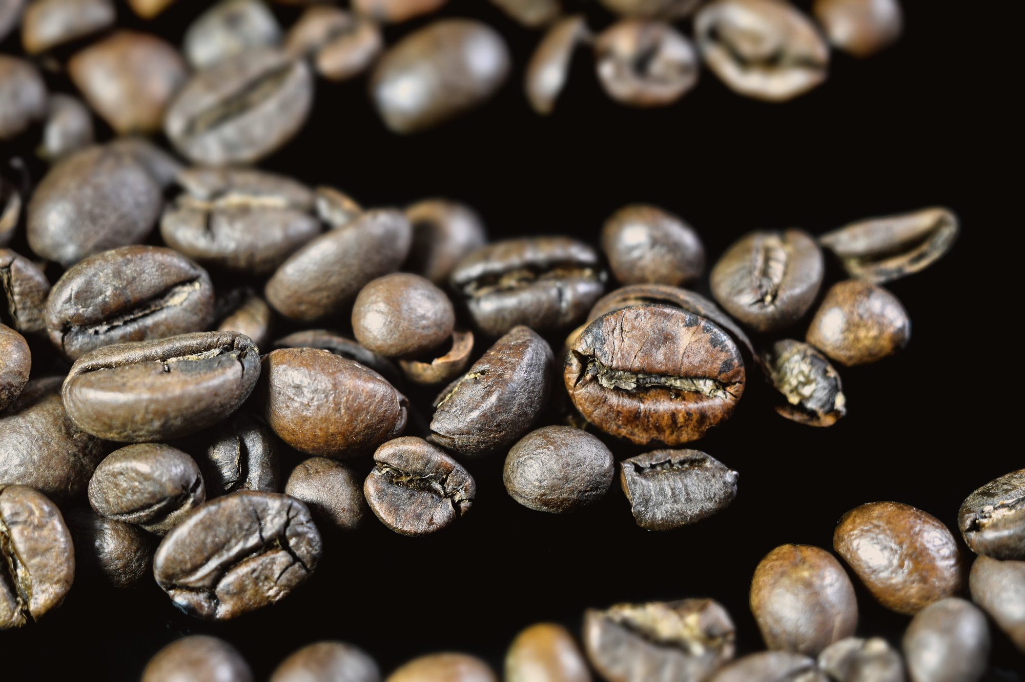 A scoop of just-roasted beans over the cooling tray, still throwing heat