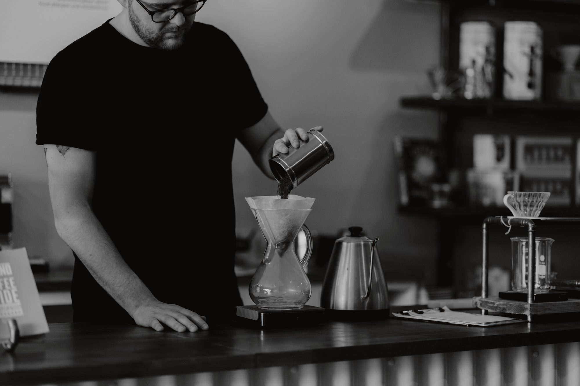 A barista dosing grounds into a pour-over at the Tidewater cafe counter